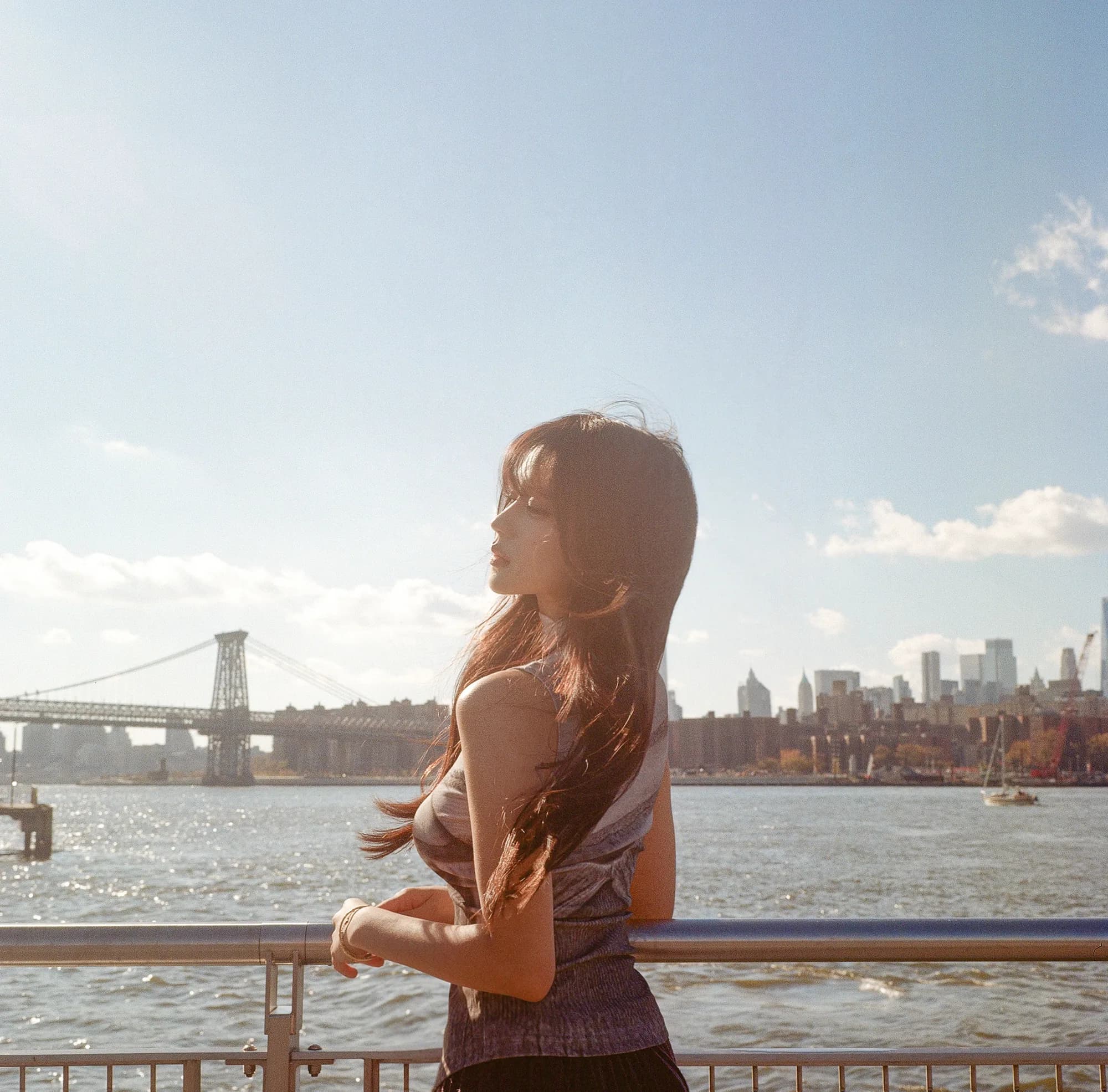 A waterfront portrait beneath pale blue sky.