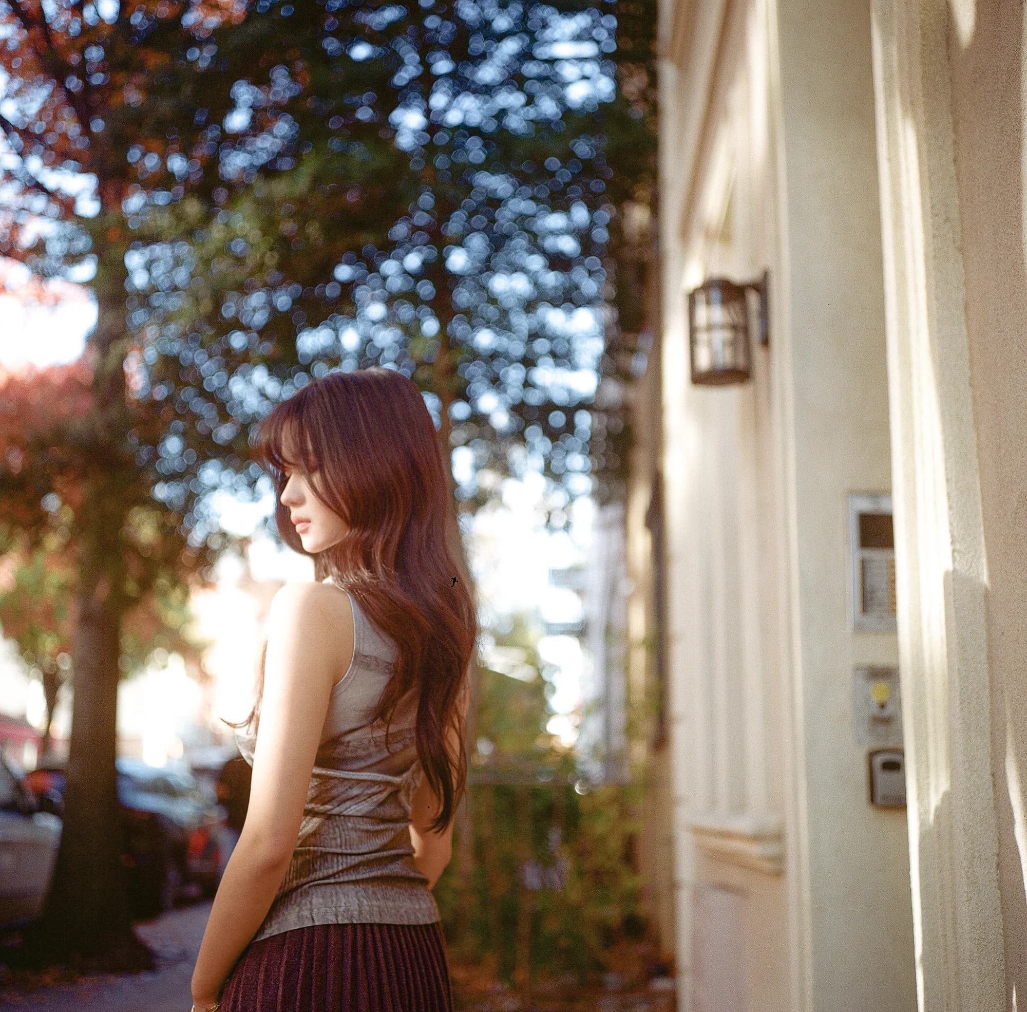 A sunlit portrait beside cream brick.