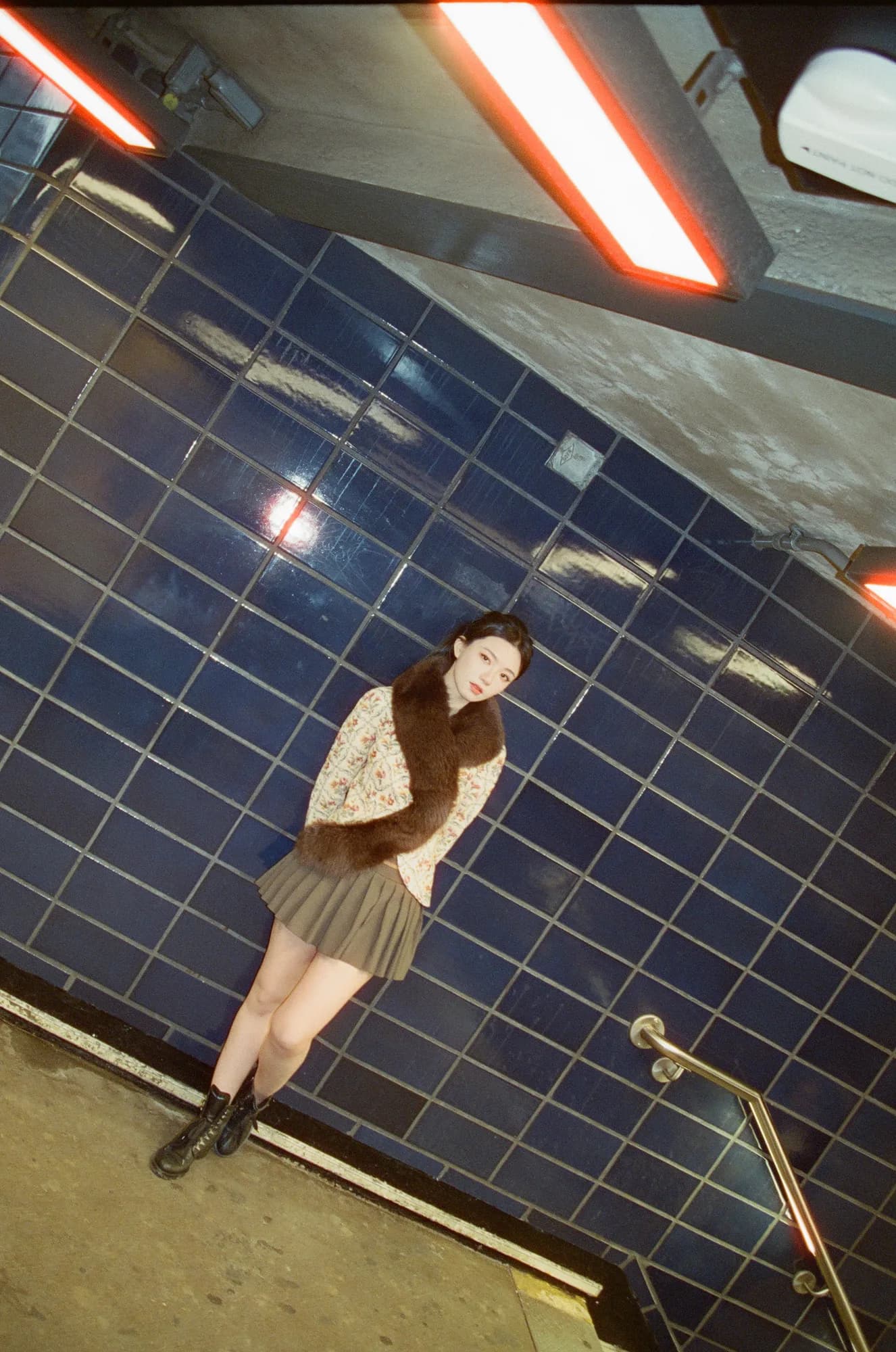 A portrait against blue subway tiles.