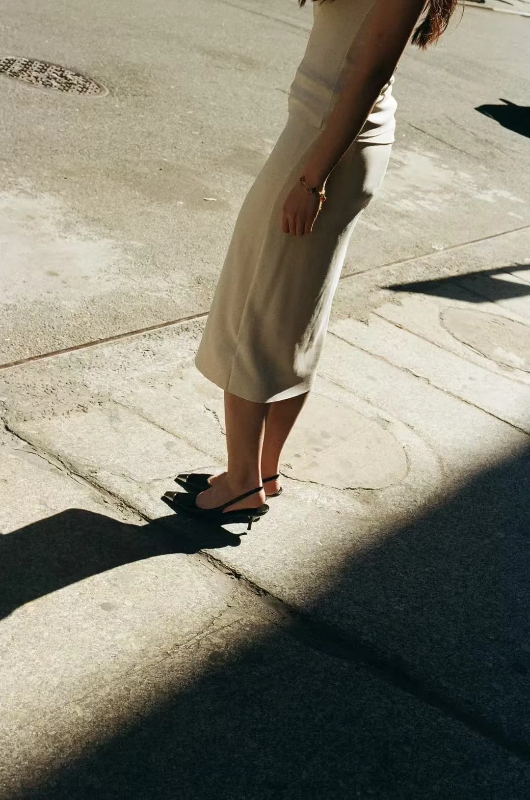 Legs crossing a boundary of light and shadow.