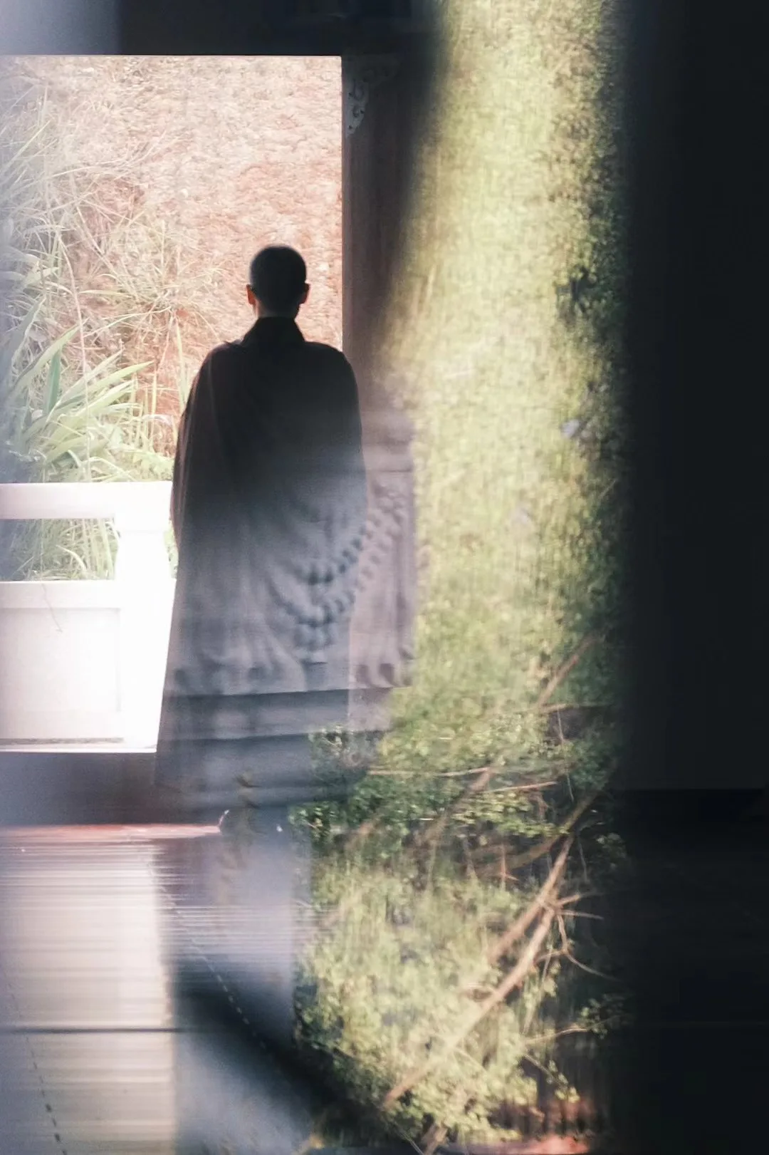 A silhouette through a softly lit curtain.