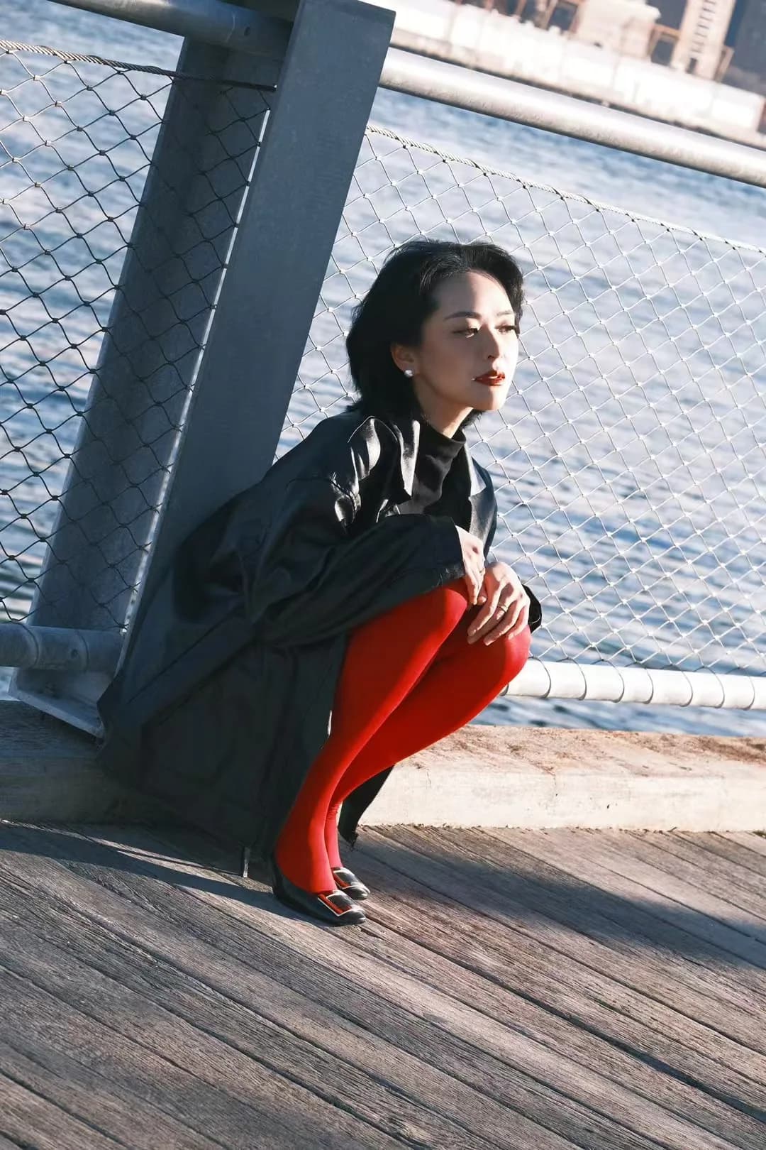 Red trousers against blue waterfront light.
