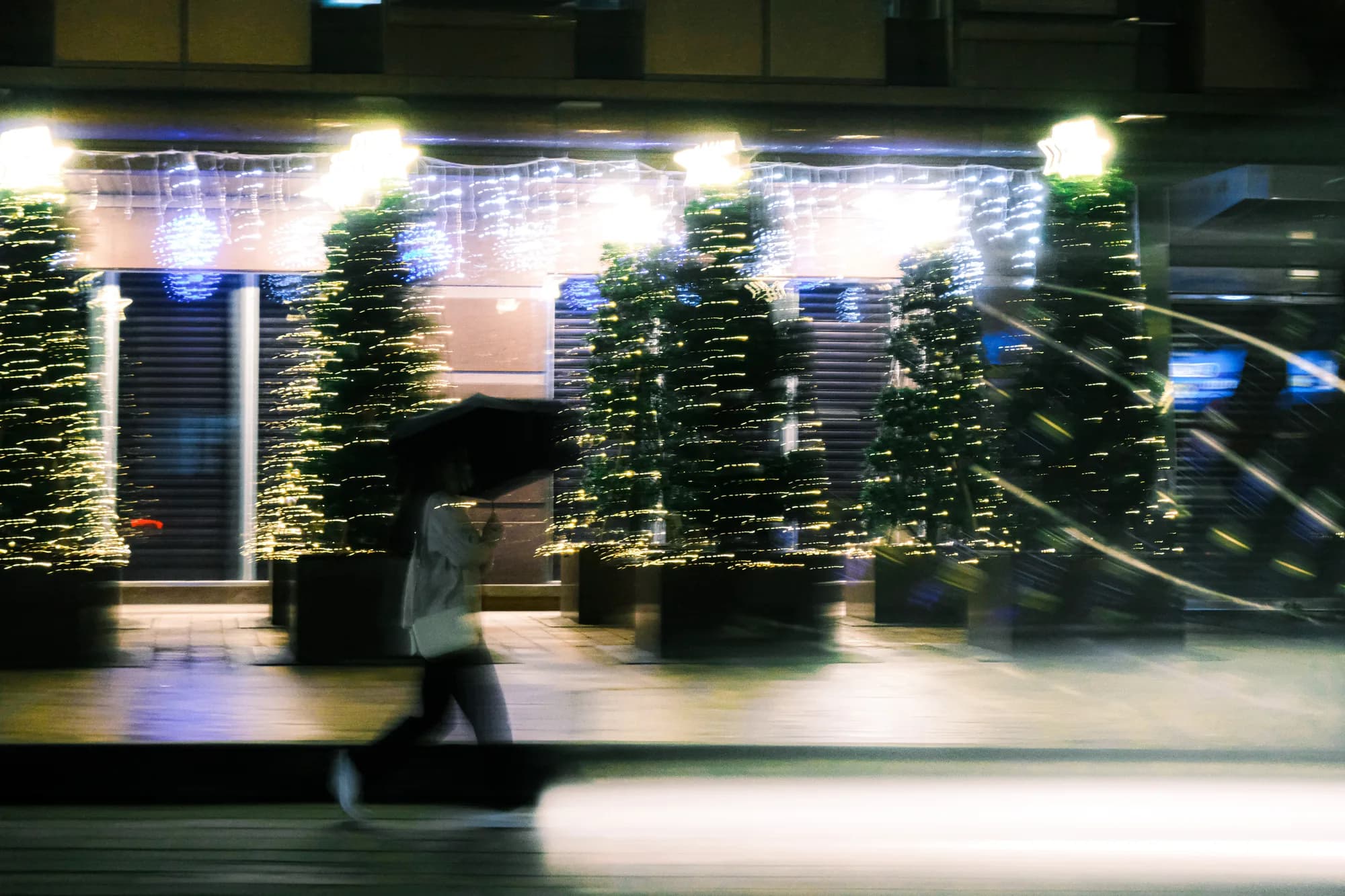 A moving figure blurred against green lights.