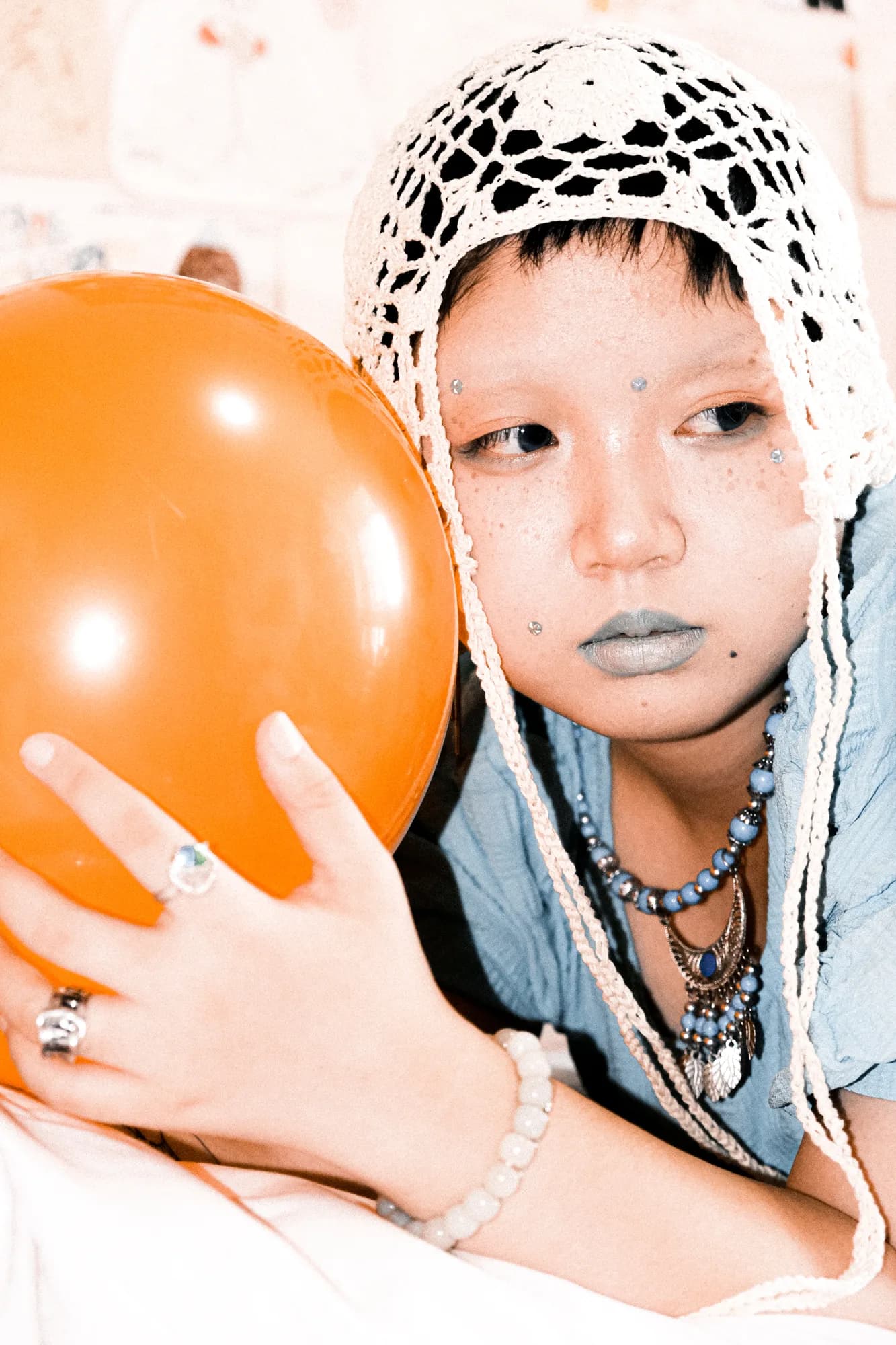 An orange balloon beside a portrait.