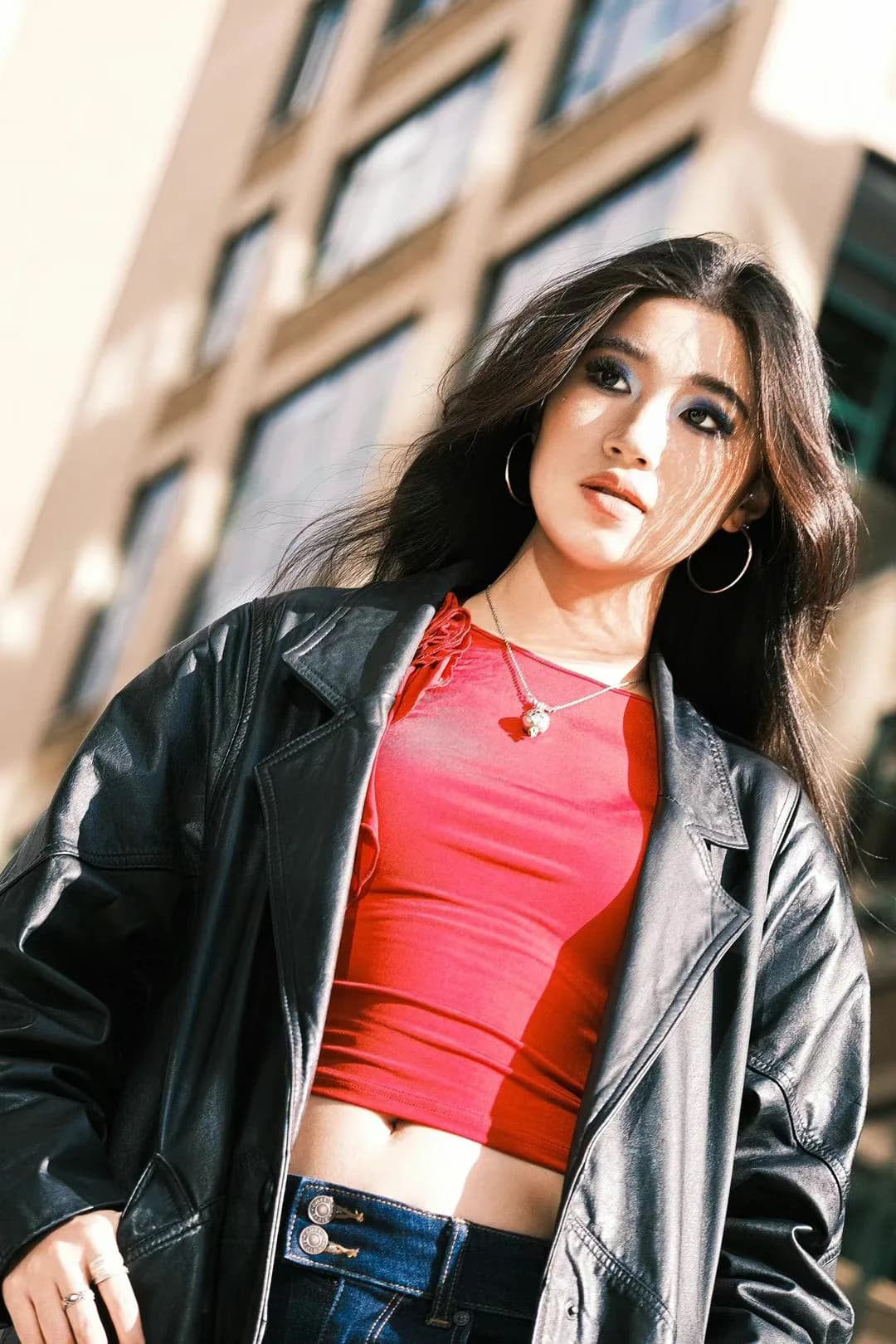 A red top beneath a dark jacket.