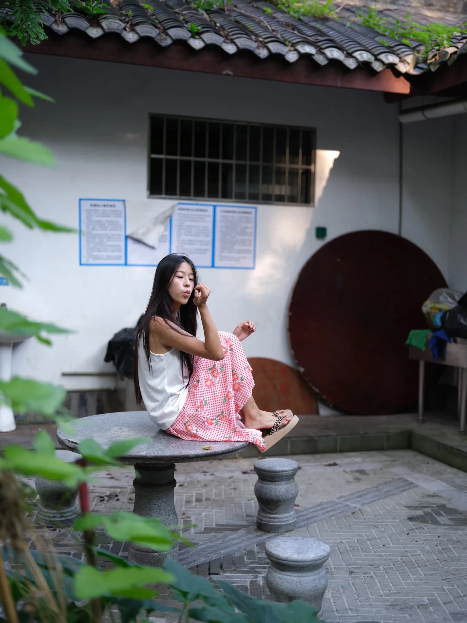 A figure in a leafy courtyard.