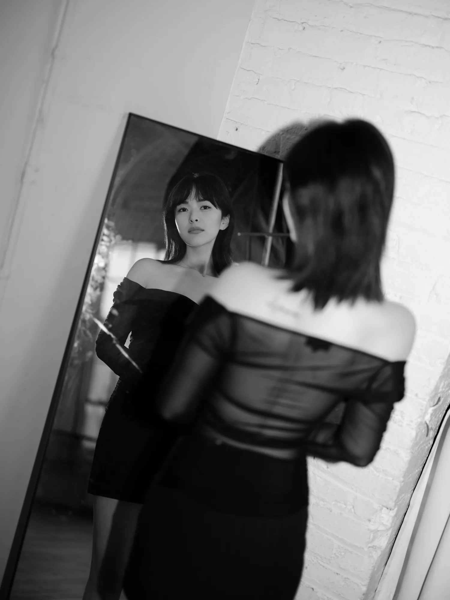 A monochrome portrait in a leaning mirror.