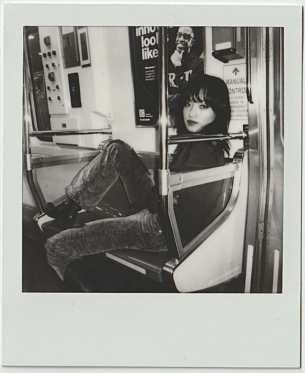 A monochrome seated instant portrait.