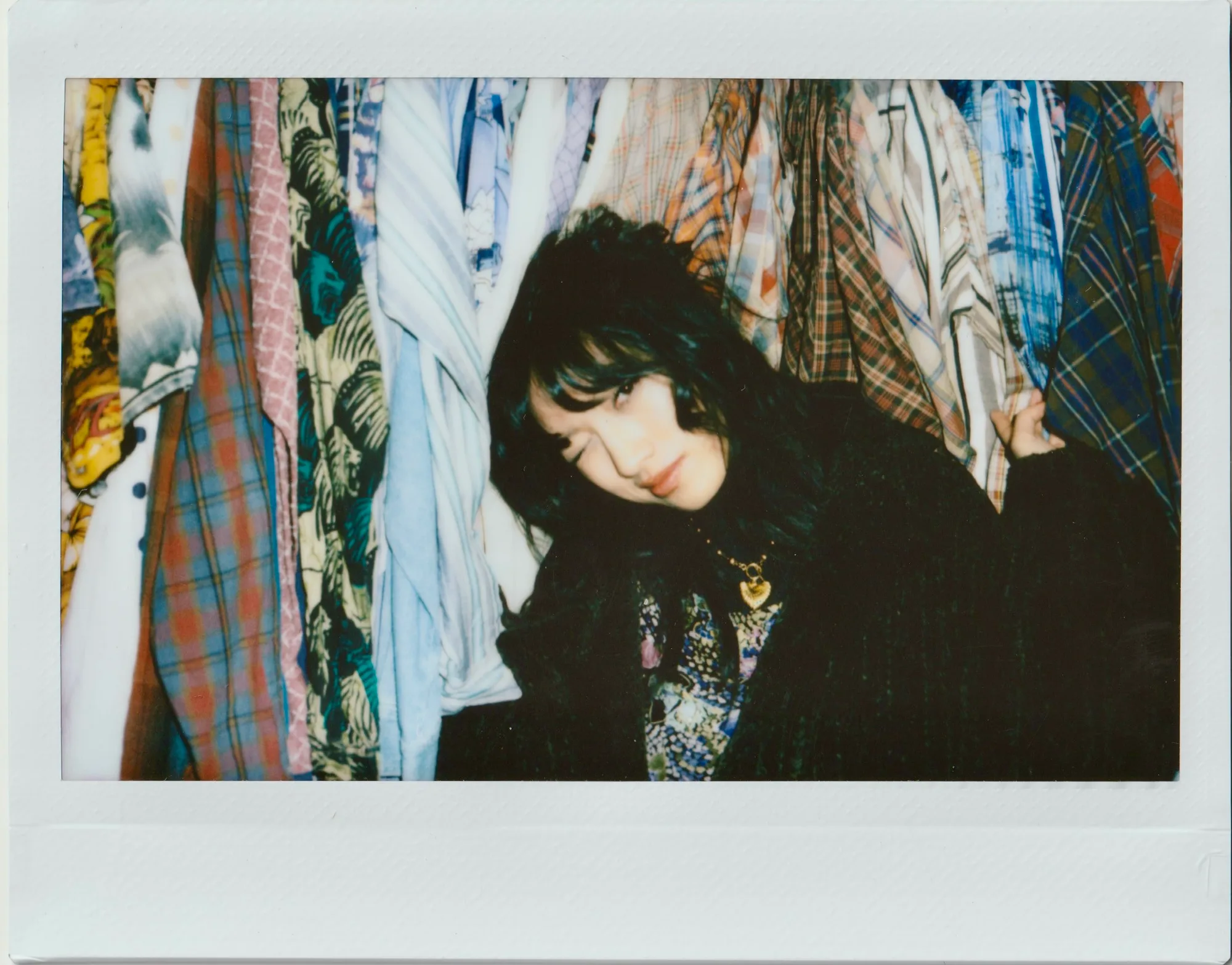 An instant portrait among multicolor clothing.