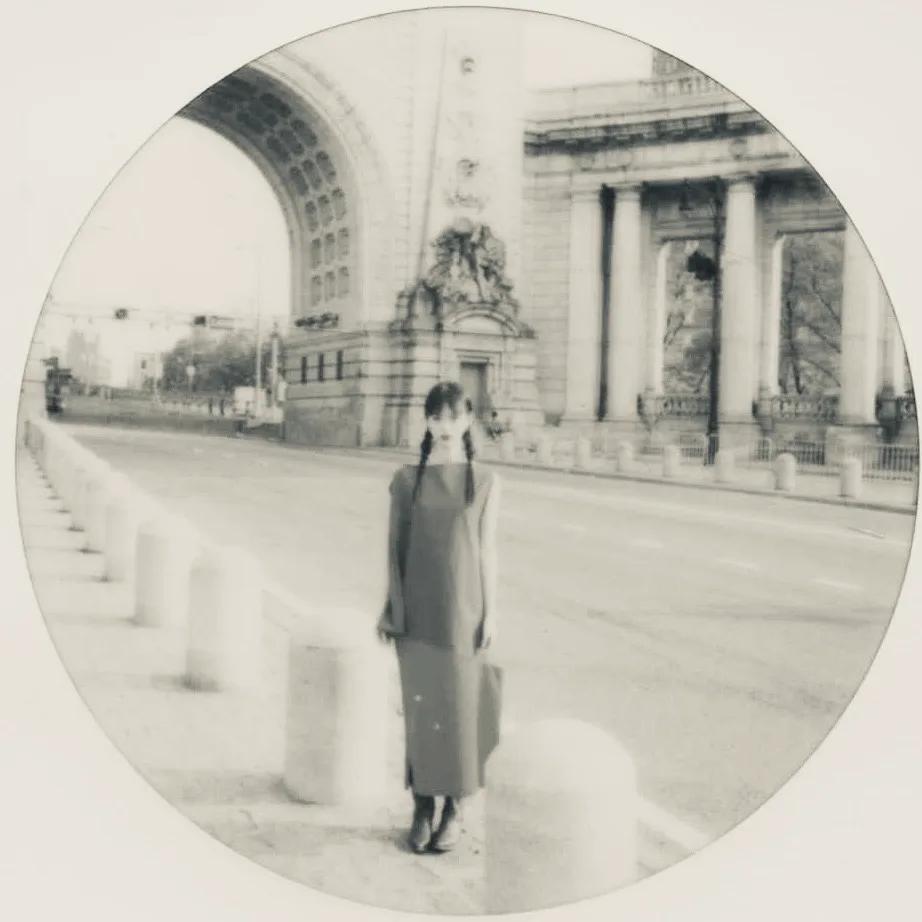 A circular monochrome street portrait.