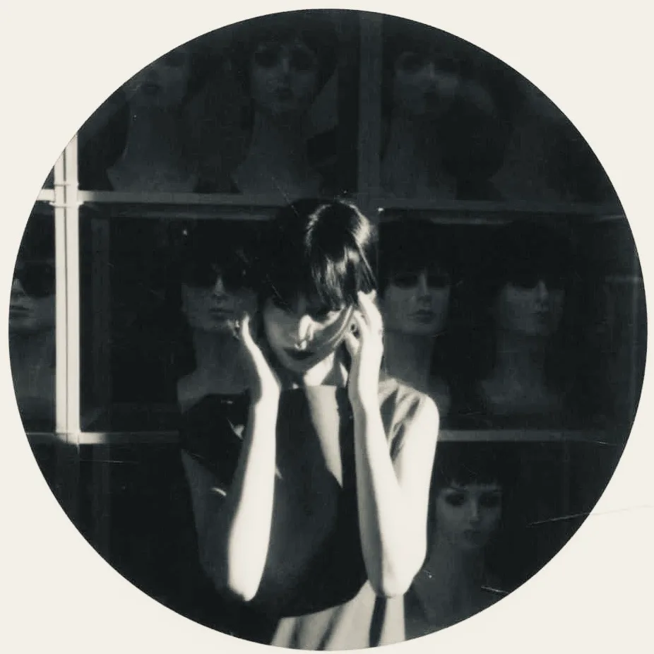 A circular monochrome window portrait.