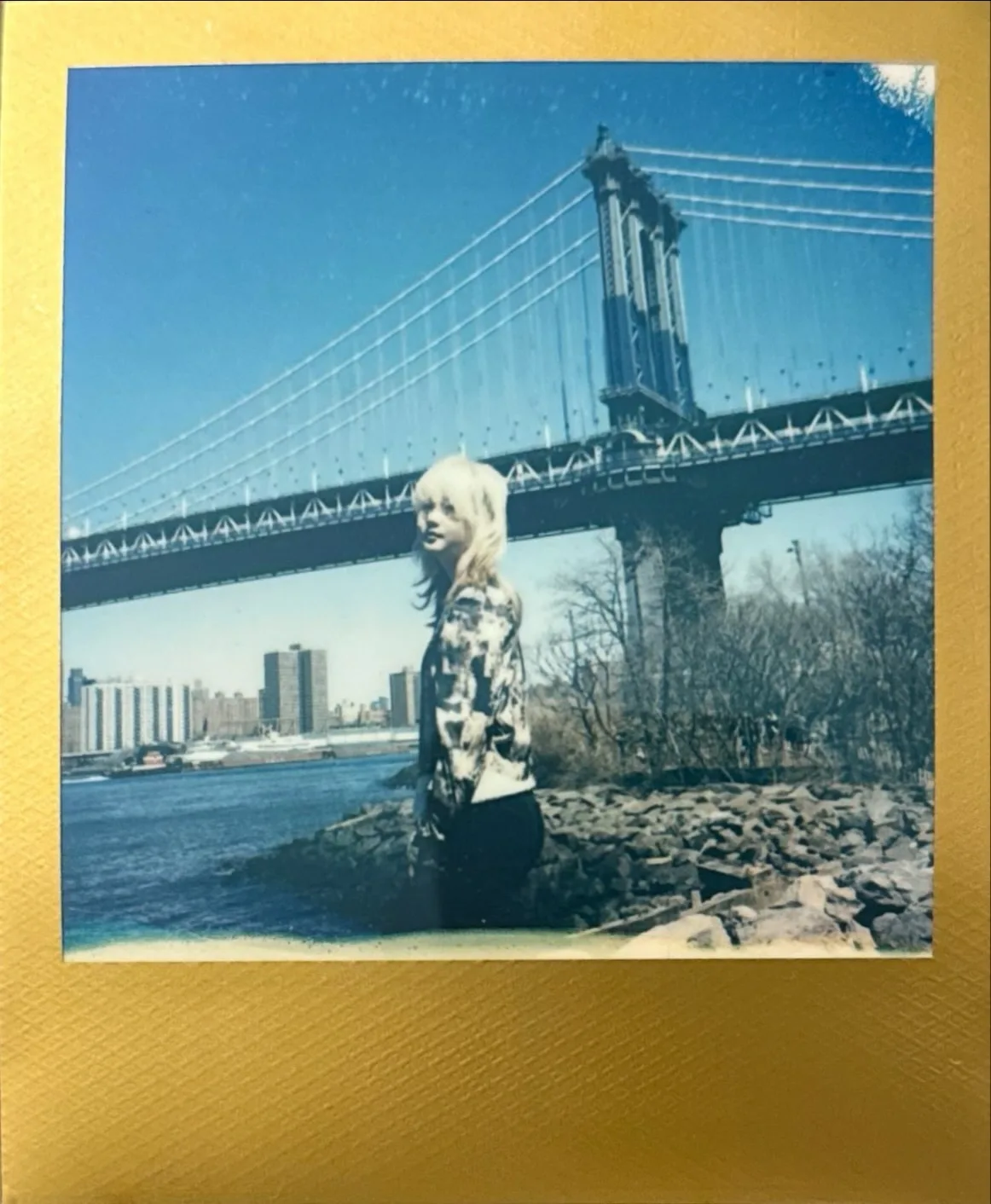 A blue waterfront instant photograph.