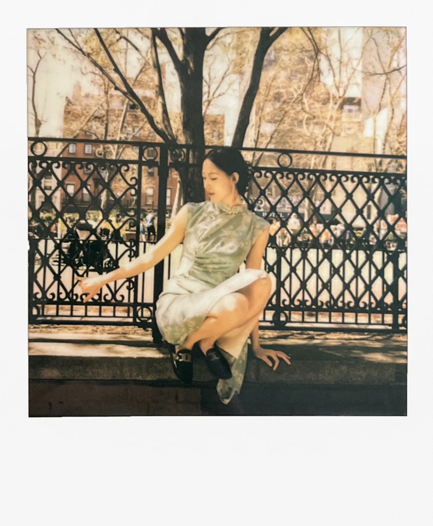 A warm instant portrait beside bare trees.
