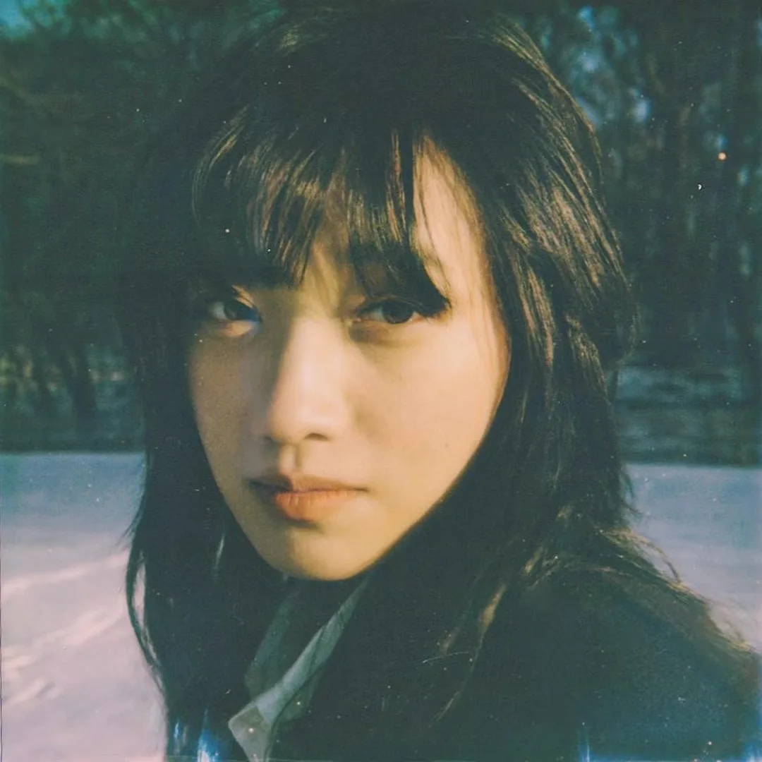 A softly focused green-toned portrait.