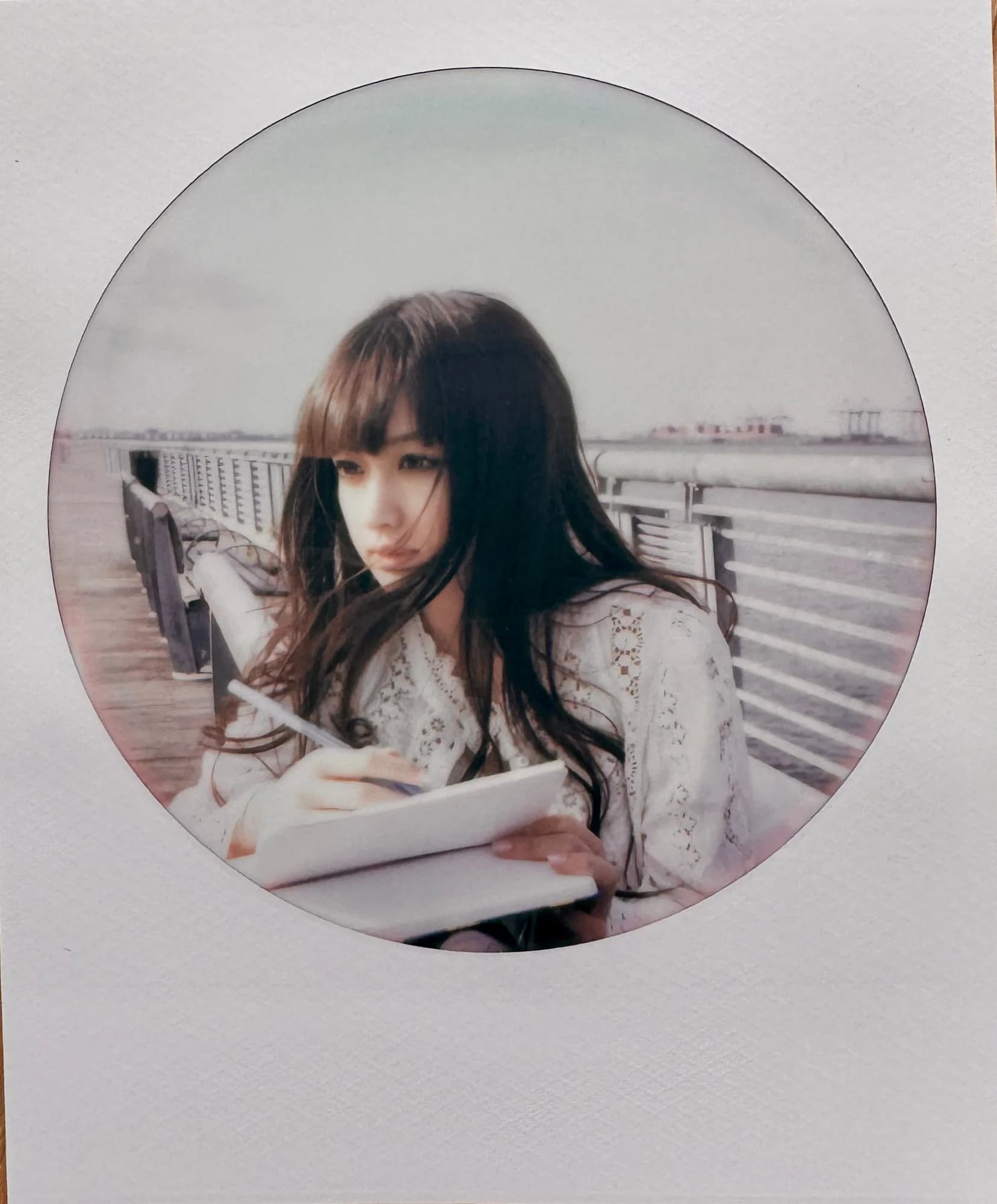 A circular desaturated waterfront portrait.
